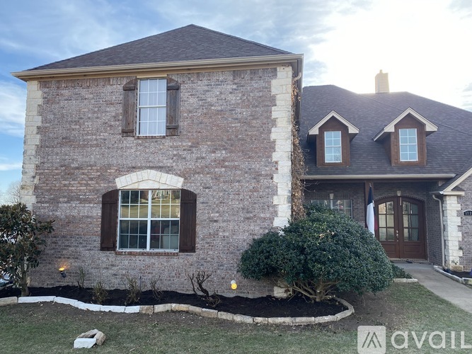 A house with a stone exterior and a brown roof.