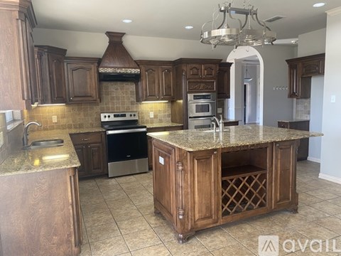 A kitchen with wooden cabinets and a granite countertop.
