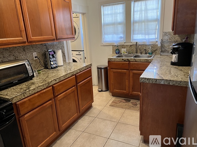 A kitchen with brown cabinets and granite countertops.