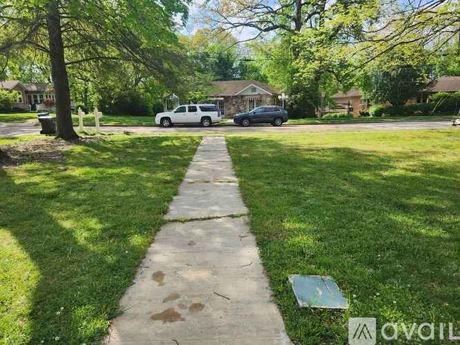 A white car is parked in a driveway.