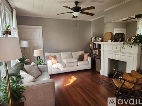 A living room with a white couch and a fireplace.