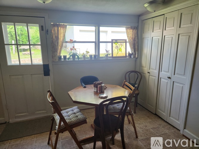 A dining room with a table and chairs.