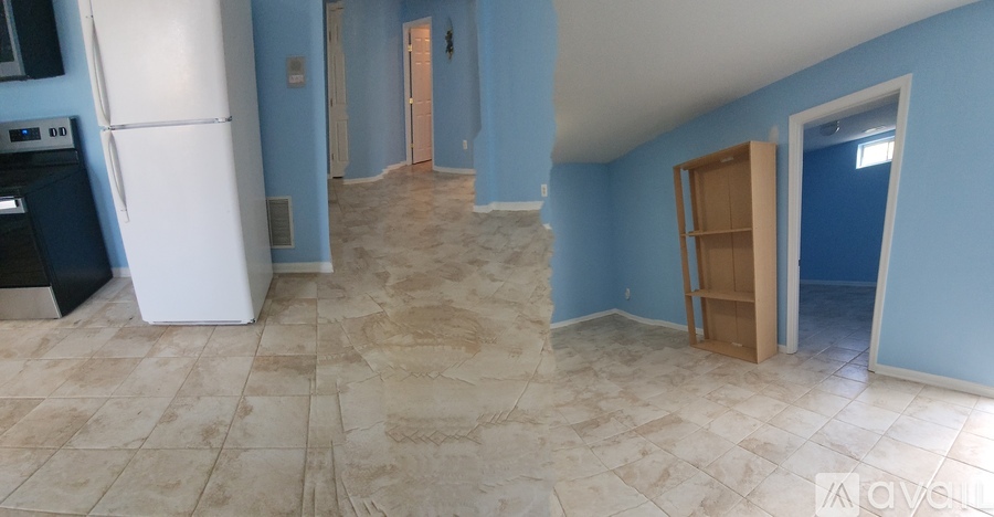 A kitchen with a white refrigerator and a tiled floor.