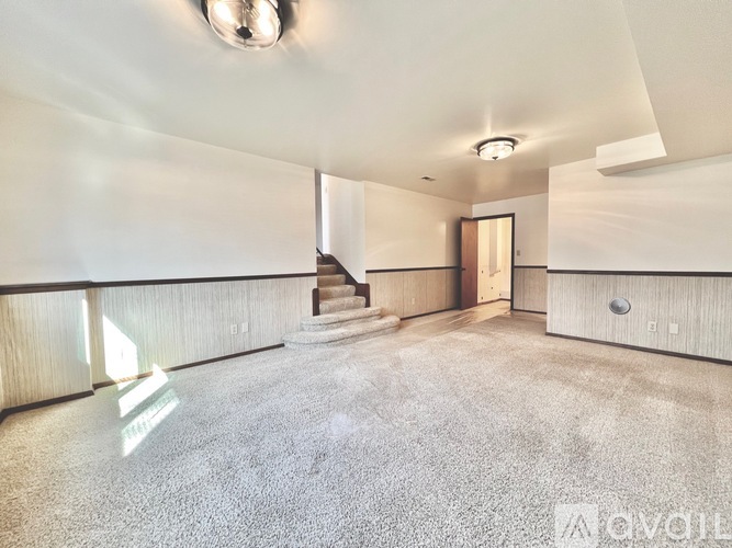 A spacious room with a staircase leading to another level.