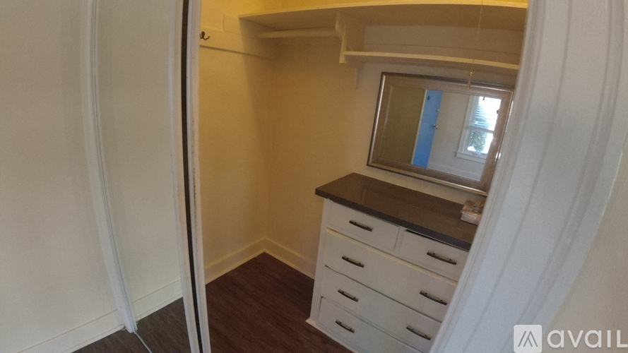 A small room with a window and a cabinet with drawers.