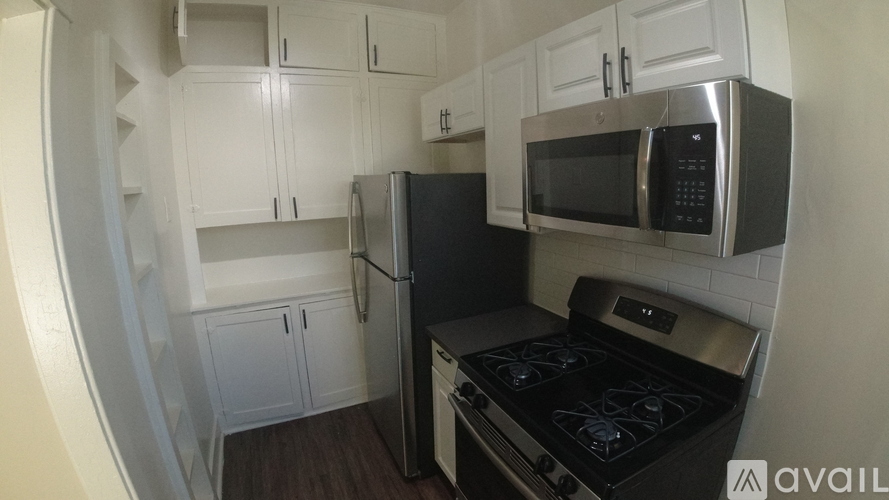 A kitchen with white cabinets and a black stove top oven.