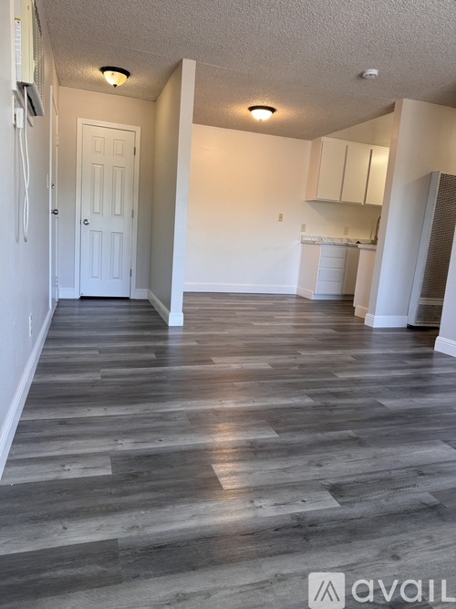 A room with wooden flooring and white walls.