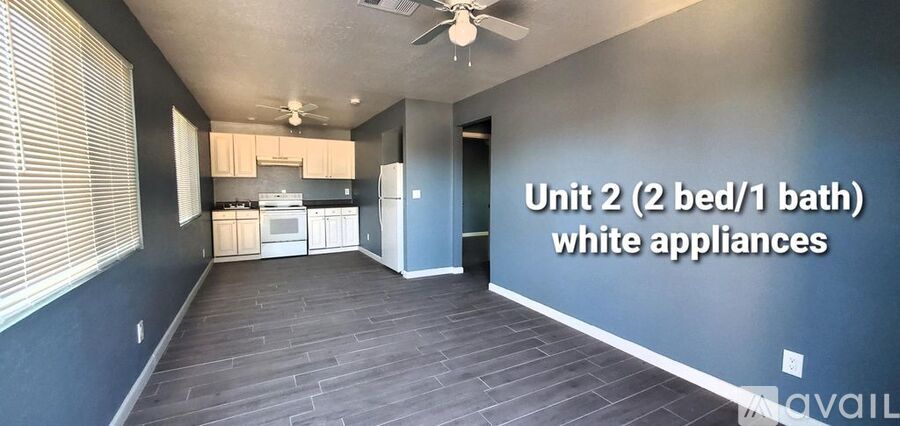 A room with a wall that says "Unit 2 (2 bed/1 bath) white appliances".