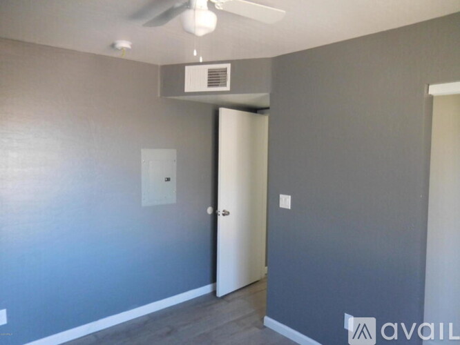 A room with a ceiling fan and a door.