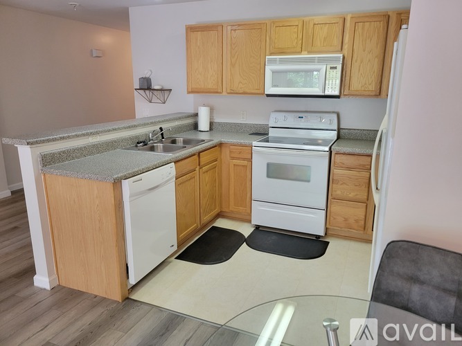 A kitchen with wooden cabinets and white appliances.