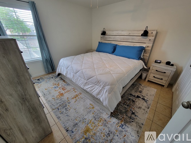 A bedroom with a white bed and a wooden headboard.