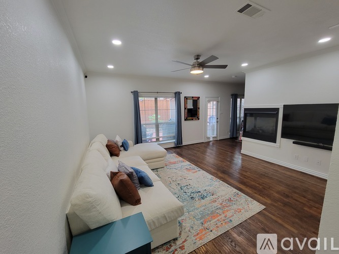 A living room with a white couch and a ceiling fan.