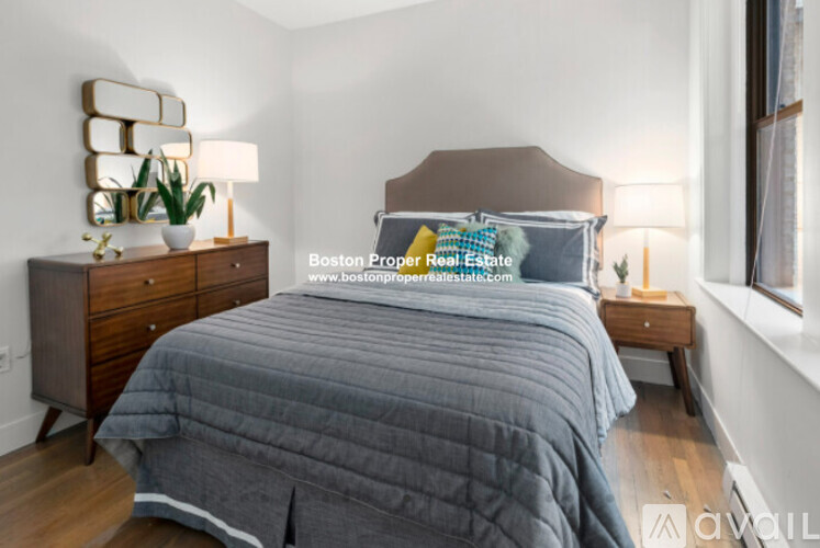 A bedroom with a bed, nightstand, and lamp.