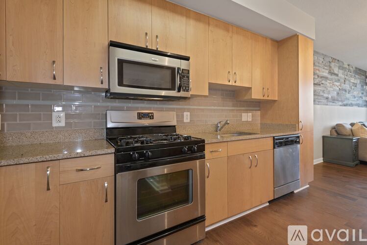 A kitchen with wooden cabinets and a stone wall.