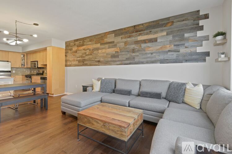 A modern living room with a grey sofa and a wooden coffee table.