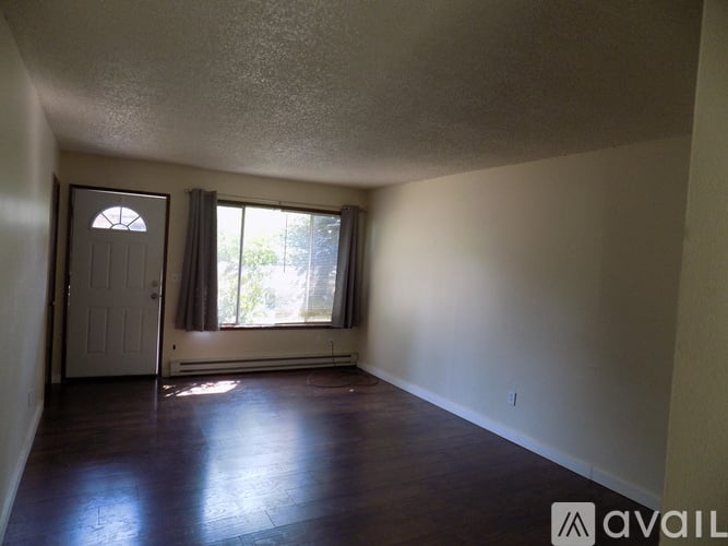 A room with a door and a window with curtains.