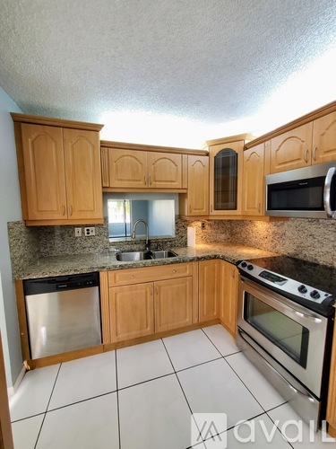 A kitchen with wooden cabinets and a black stove top oven.