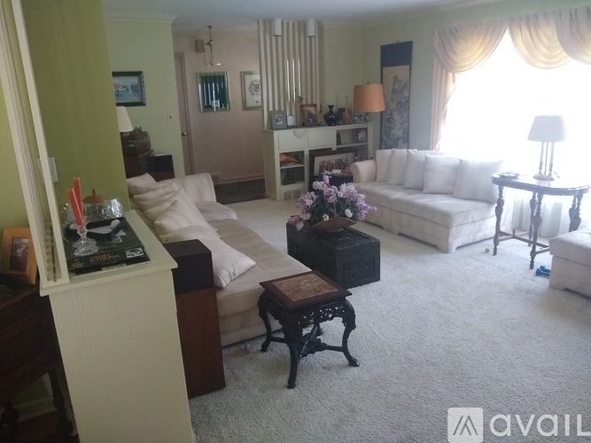 A living room with a white couch, a coffee table, and a lamp.