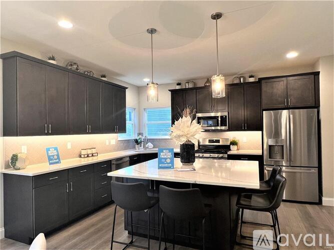 A modern kitchen with black cabinets and a central island.