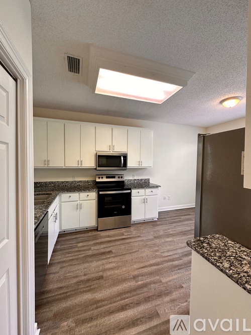 A kitchen with white cabinets and a granite countertop.