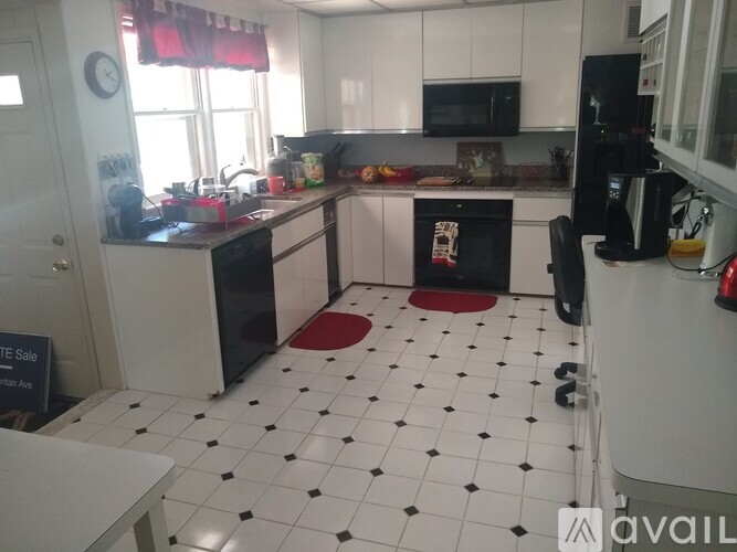 A kitchen with black and white tiles and white cabinets.