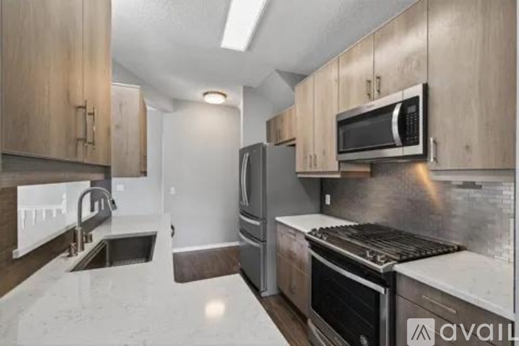 A kitchen with a sink, stove, and refrigerator.
