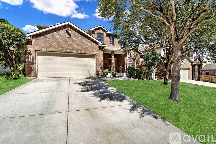A house with a garage and a tree in front.