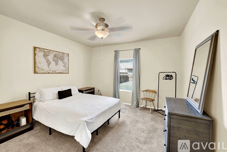 A bedroom with a bed, dresser, and mirror.