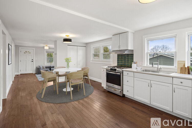 A kitchen with white cabinets and a wooden floor.
