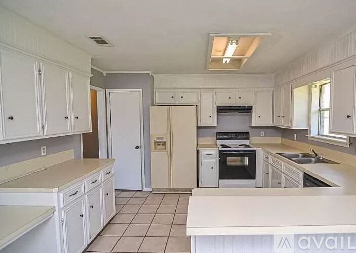 A kitchen with white cabinets and appliances.