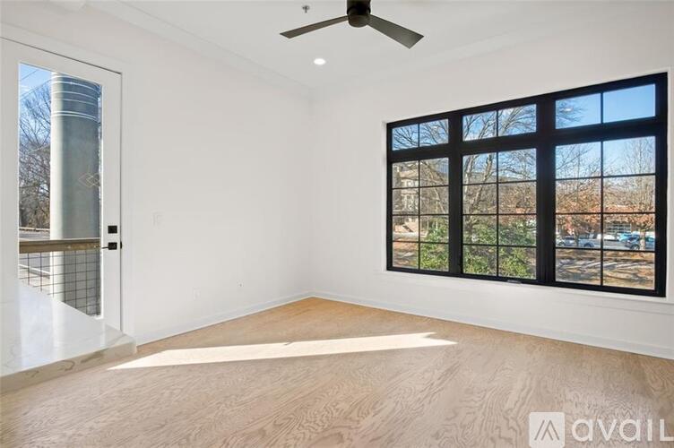 A room with a large window and a fan on the ceiling.