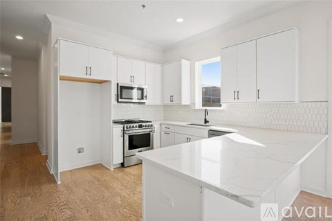 A kitchen with white cabinets and a white countertop.