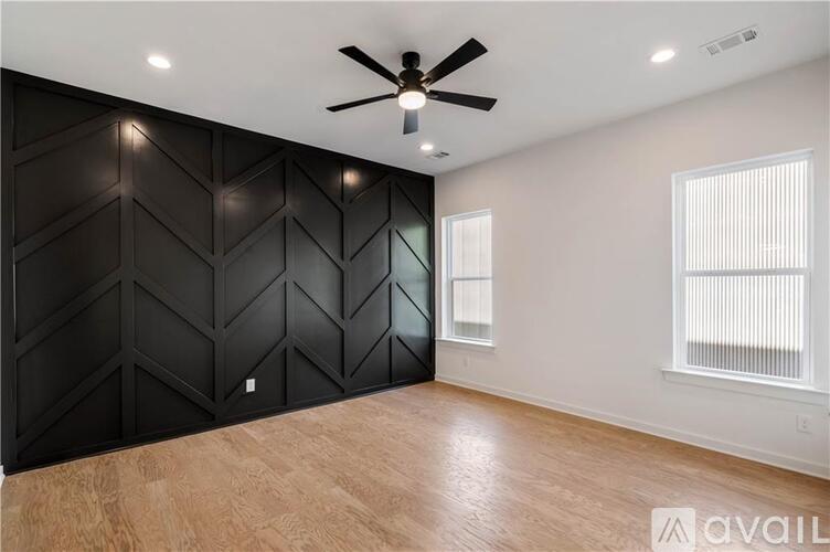 A room with a black wall and a ceiling fan.