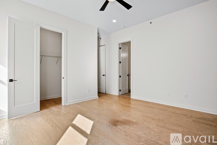 A room with a ceiling fan and wooden flooring.
