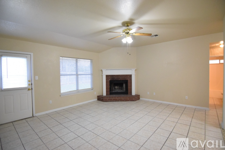 A living room with a fireplace and a ceiling fan.