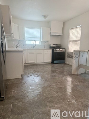A kitchen with a tile floor and a refrigerator.