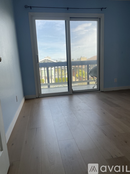 A room with a sliding door leading to a balcony.