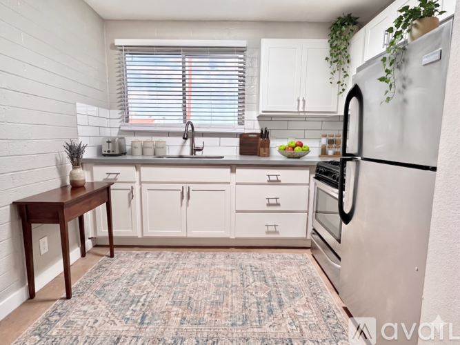 A kitchen with white cabinets and a refrigerator.