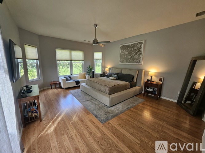 A bedroom with a large bed and a ceiling fan.