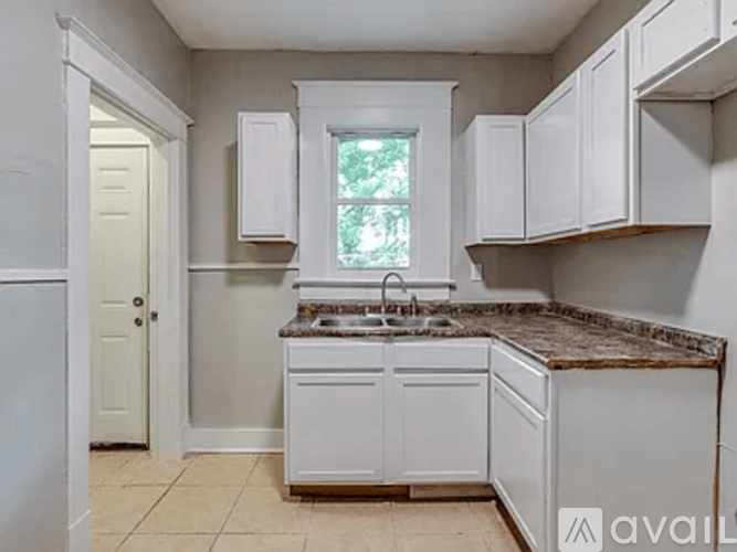 A kitchen with white cabinets and a granite countertop.