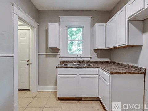 A kitchen with white cabinets and a granite countertop.