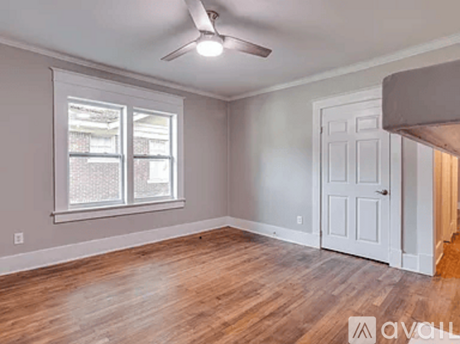 A room with a ceiling fan and a door.