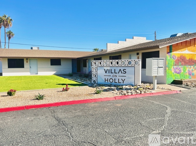 A sign that says Villas on Holly in front of a building.