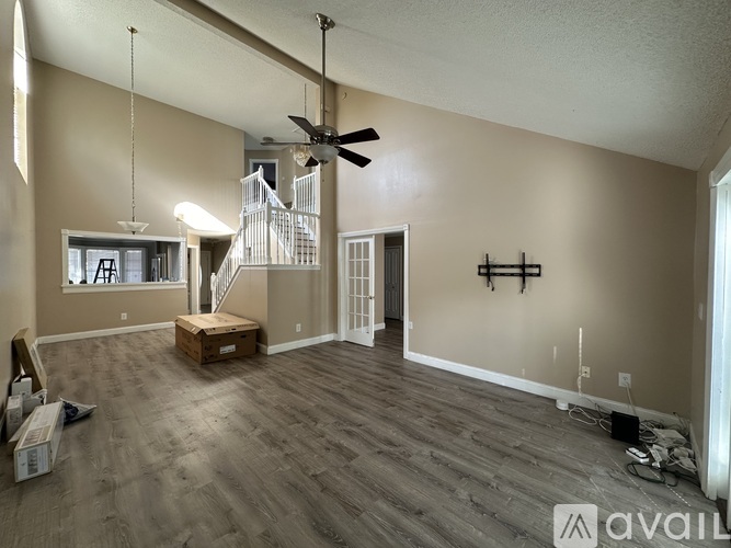 A room with a ceiling fan and a staircase.