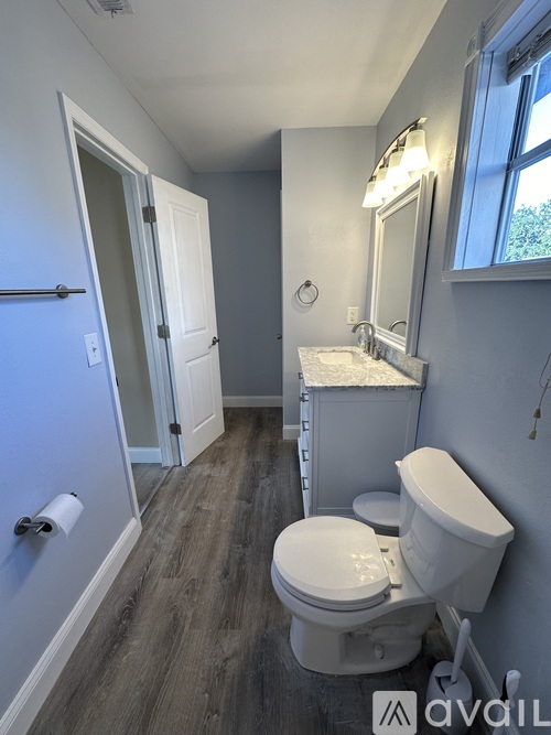 A bathroom with a toilet, sink, and mirror.