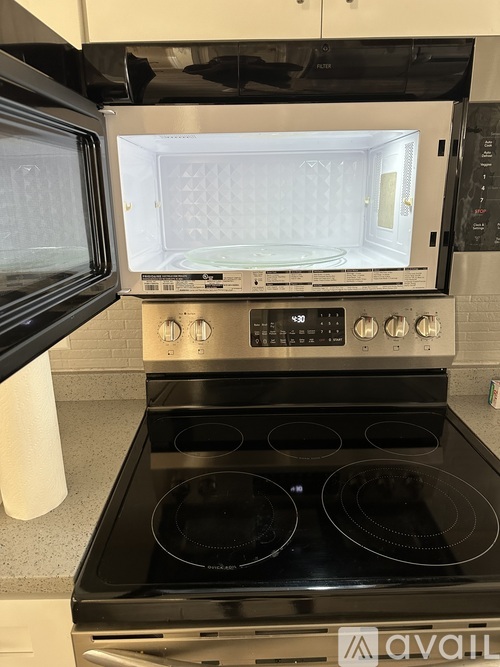 A modern kitchen with a black stove top oven and a microwave above it.