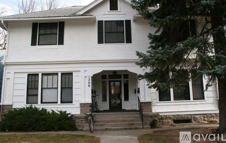 A white house with a black bicycle leaning against the front door.