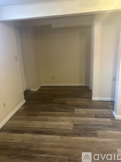 A room with wooden flooring and white walls.