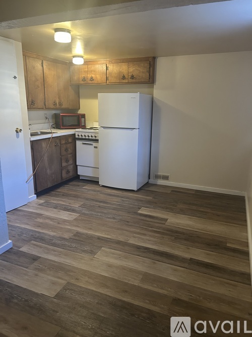 A kitchen with a white refrigerator and wooden cabinets.