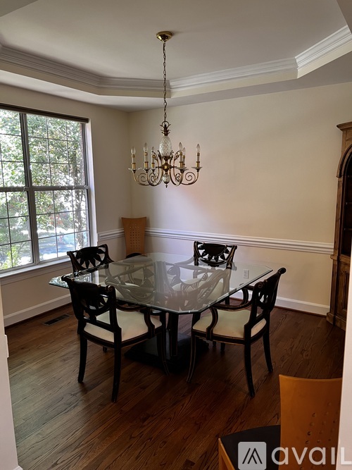 A dining room with a glass table and chairs.